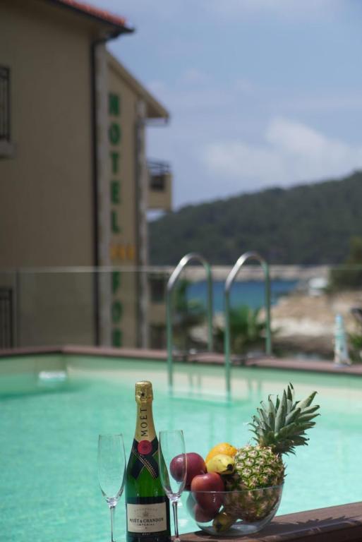 un tavolo con un cesto di frutta e una bottiglia di vino di Hotel Fortuna a Hvar