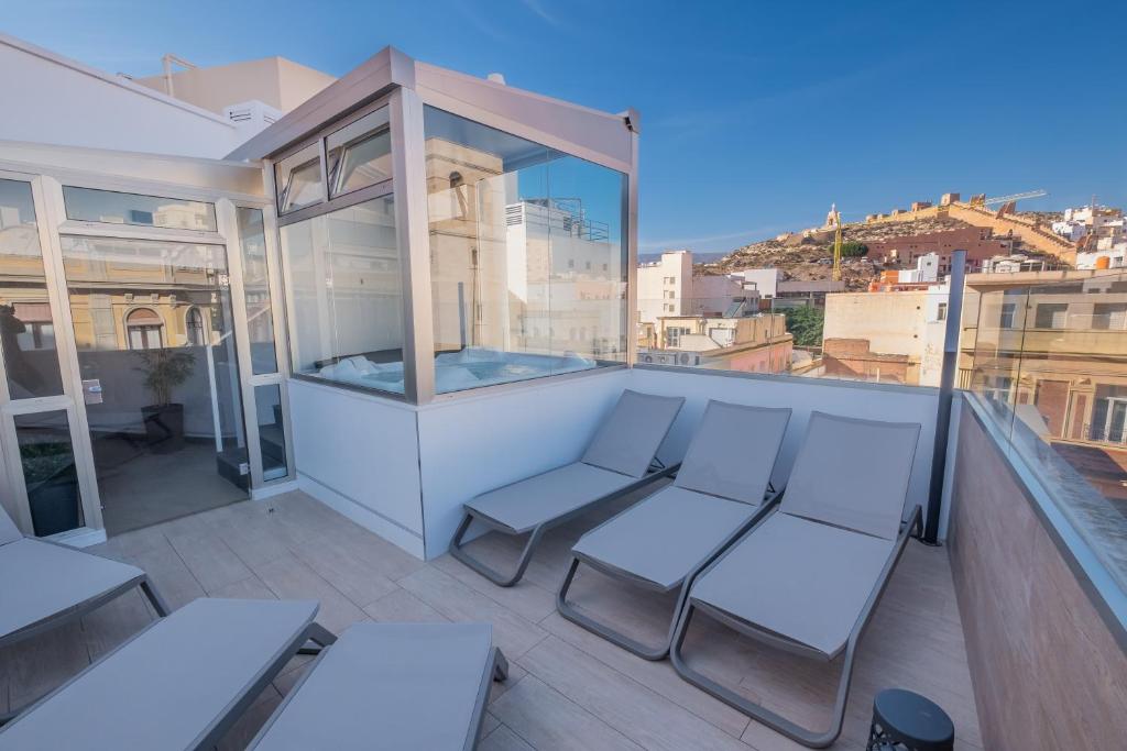 a balcony with white furniture and a view of a city at Nuevo Torreluz in Almería