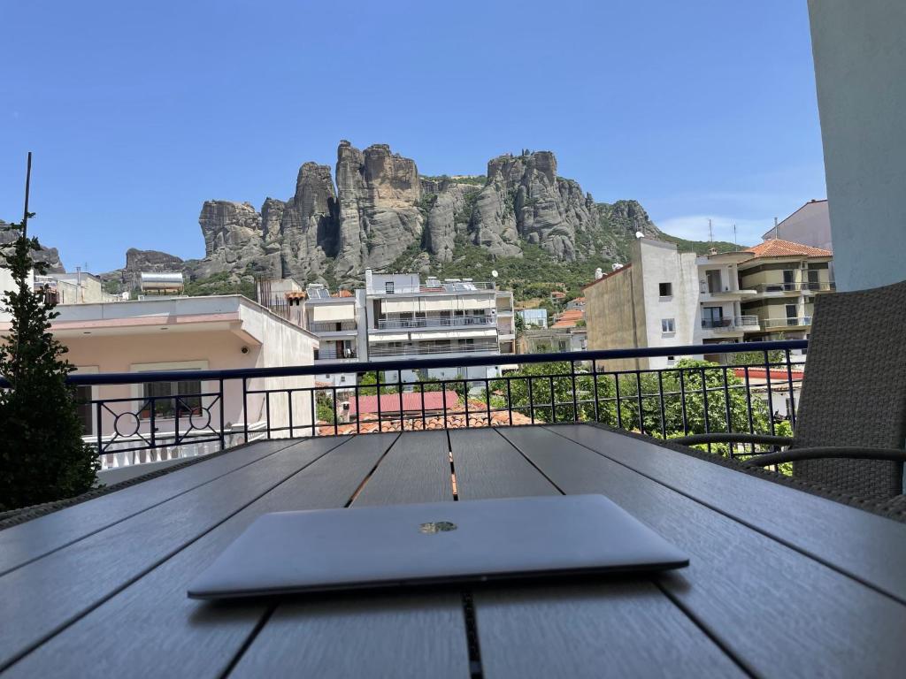 a laptop sitting on top of a wooden table on a balcony at Meteora Casa Di Stella in Kalabaka