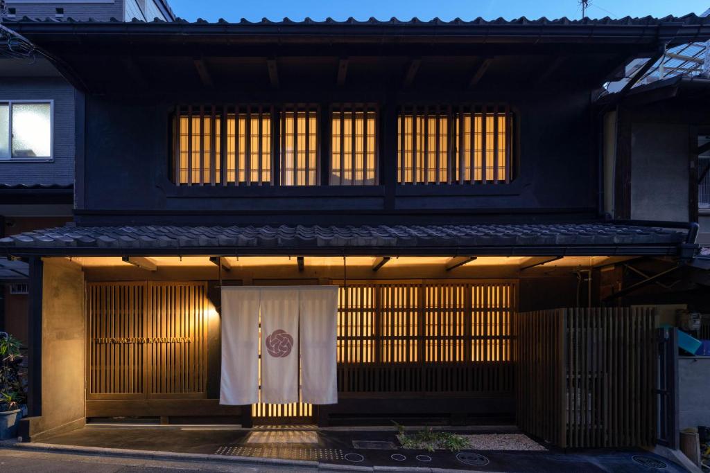 a black house with a white curtain in front of it at The Machiya Kamiumeya in Kyoto