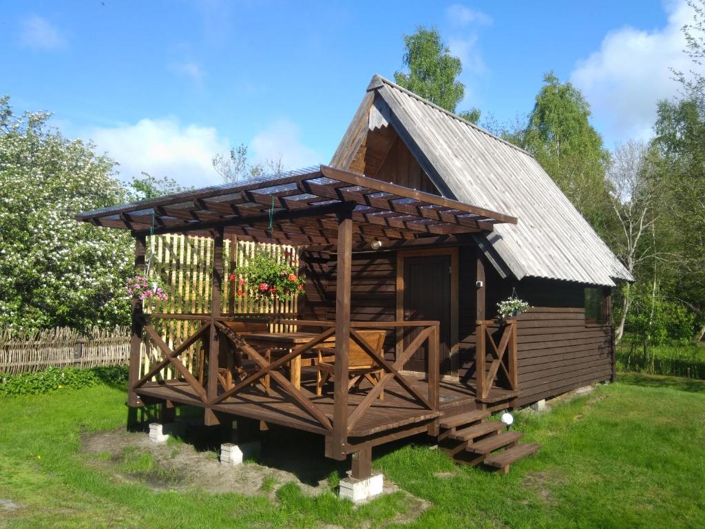 a small wooden cabin with a roof at Pie Andra Pitragā in Pitragutsiyeme