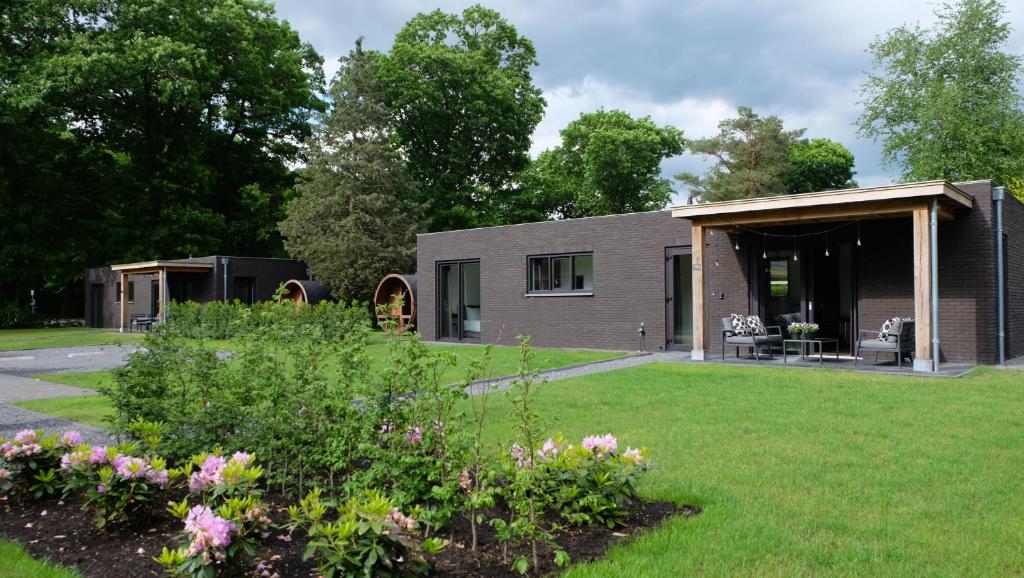 a house with a garden in front of it at The Black Oak - Luxe bungalow met prive sauna in Voorthuizen