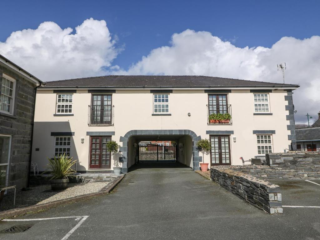 a large white building with an archway at 9 The Oakleys in Porthmadog