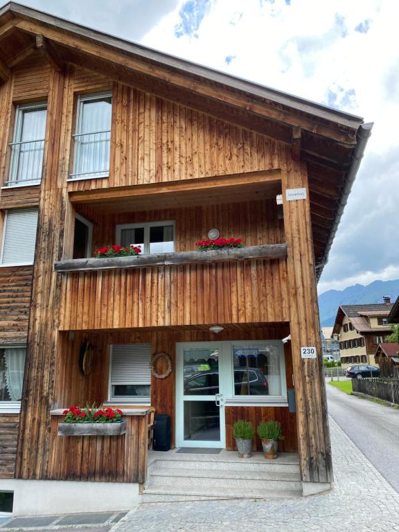 drewniany dom z balkonem przy ulicy w obiekcie Haus Emma w mieście Schoppernau