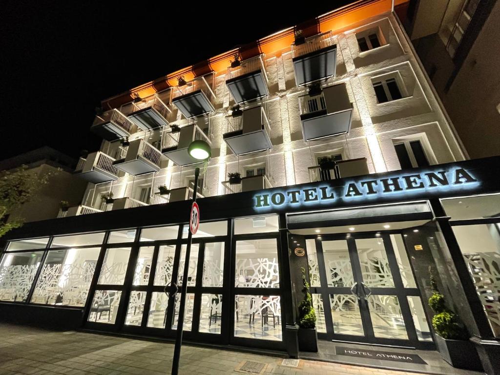 un edificio con hotel por la noche en Hotel Athena en Lignano Sabbiadoro