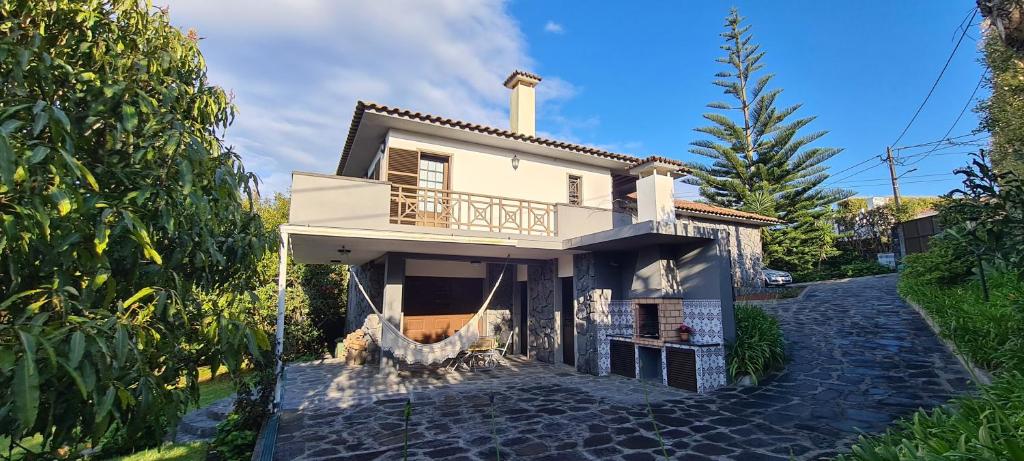 a white house with a balcony on a street at Descanso do Guerreiro in Ribeira Grande