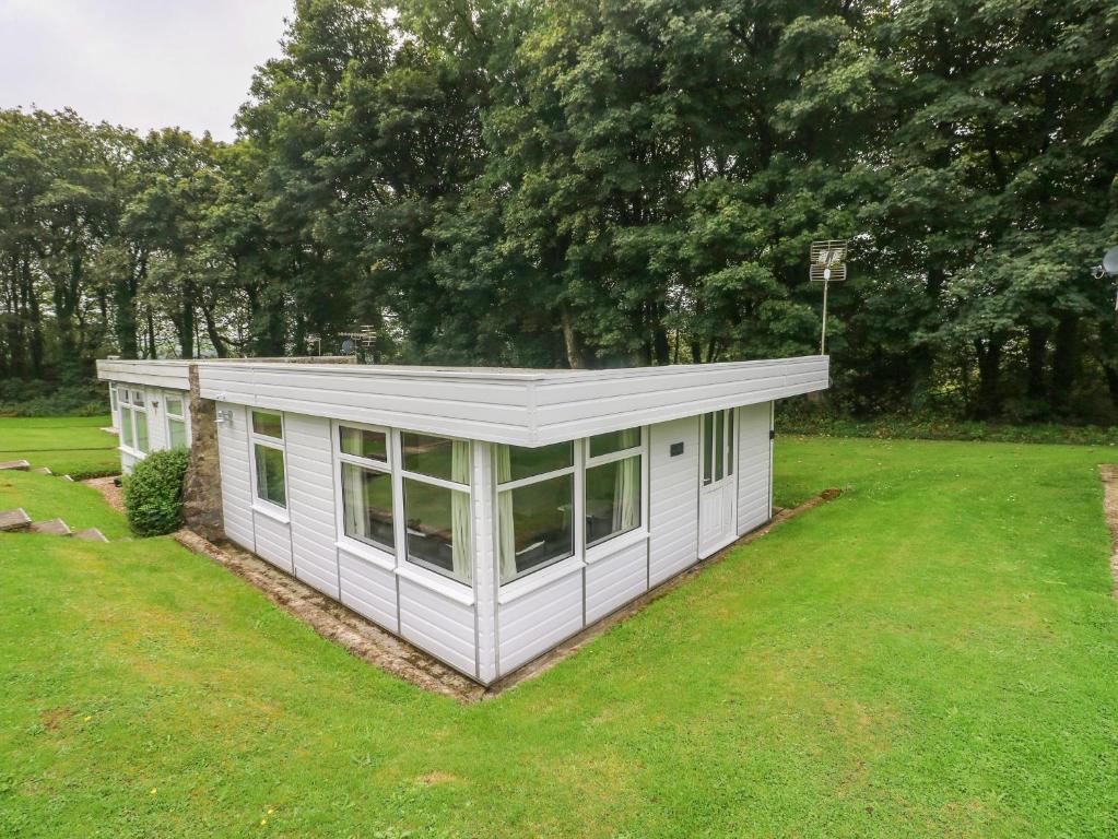 a small white house in a field of grass at Saltwater in Haverfordwest