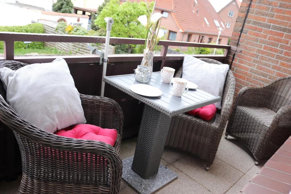 uma mesa e duas cadeiras numa varanda com uma mesa e duas cadeiras em Haus Laura Wohnung 1 em Büsum