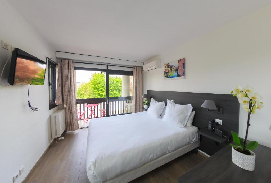 Postel nebo postele na pokoji v ubytování Logis hôtel Annecy nord / Argonay