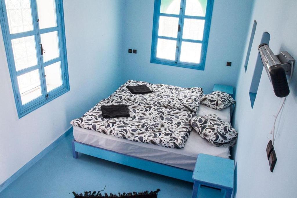 Cette chambre bleue comprend un lit avec des oreillers. dans l'établissement Room in Guest room - Pretty room in villa Lair De La Mer, in Sidi Kaouki, à Sidi Kaouki
