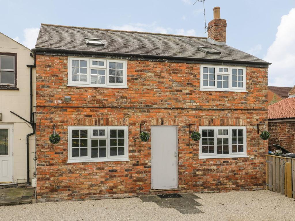 a red brick house with a white door at New Inn Apartment in York