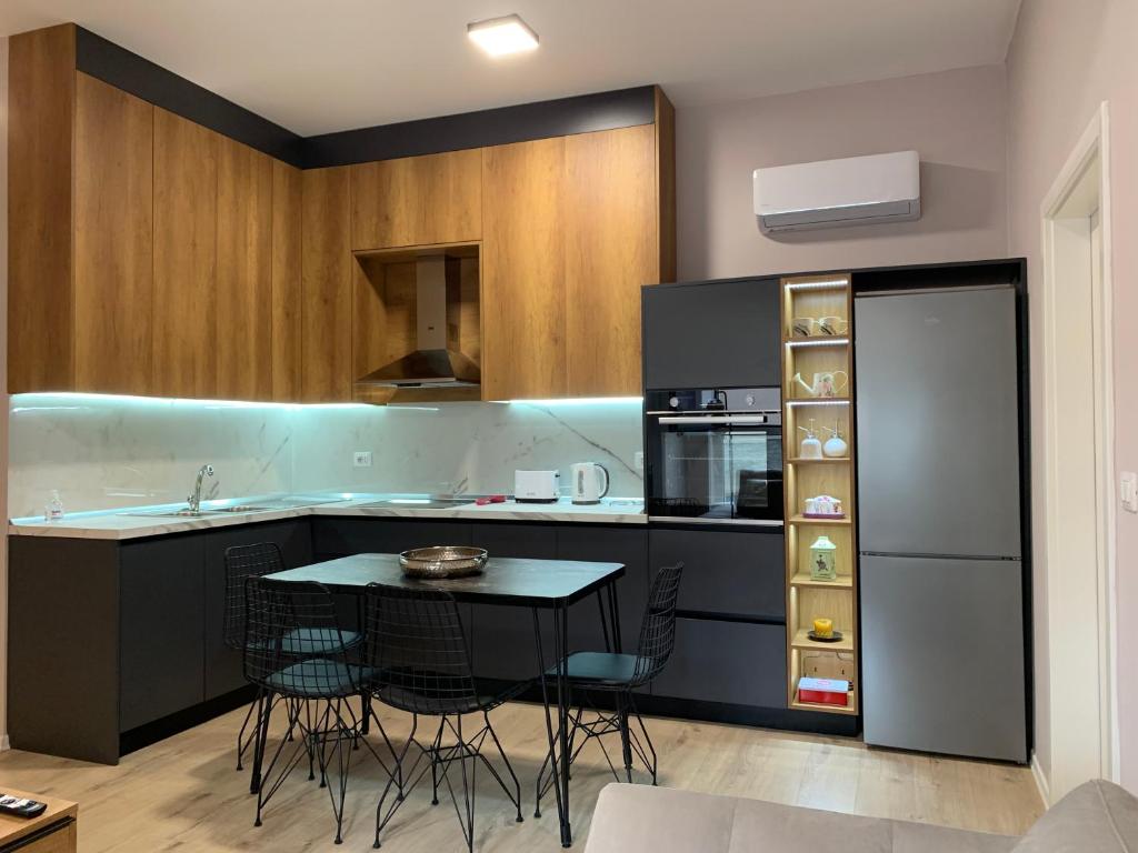 Lovely 1-bedroom Condo in Tirana WiFi-Netflix-AC في تيرانا: مطبخ مع طاولة وكراسي في مطبخ