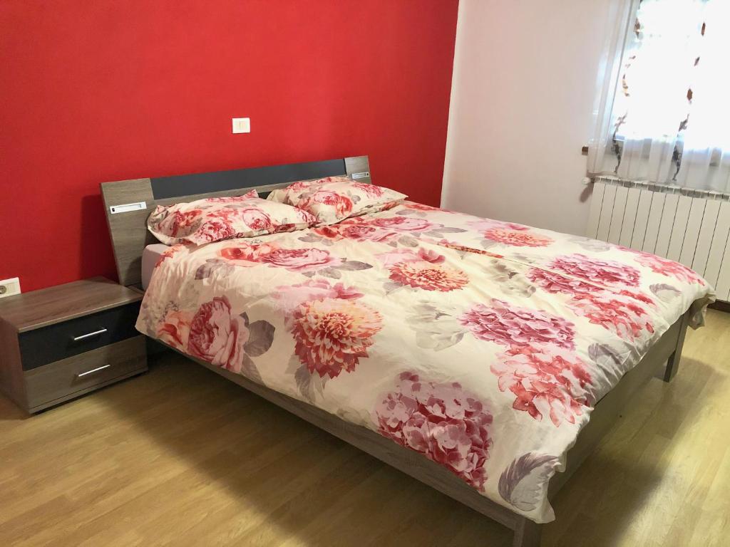 un letto in una camera da letto con parete rossa di Apartmaji Mlekuž a Bovec