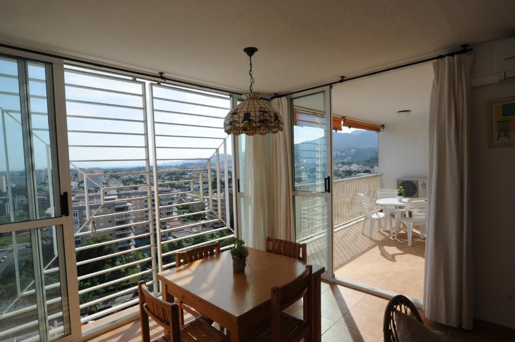 a dining room with a table and a large window at AMANECER vista mar Orangecosta in Benicàssim