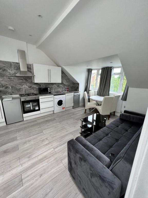 uma sala de estar com um sofá e uma mesa em Lovely 2 Bedroom Flat with Roof Terrace in London NW6 em Londres