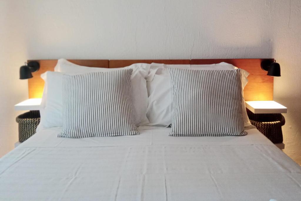 Una cama blanca con dos almohadas encima. en Apartment on the beach by amcf, en Alvor