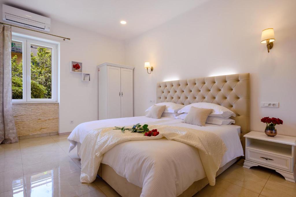a bedroom with a large white bed with flowers on it at Summer breeze luxury rooms in Split