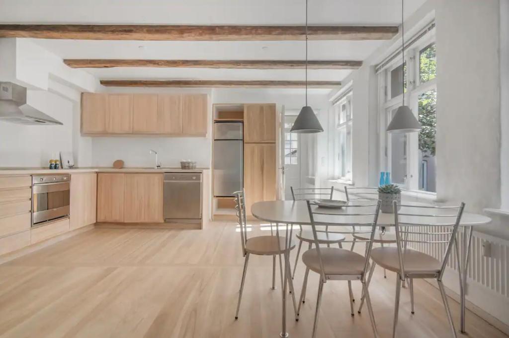 a kitchen and dining room with a table and chairs at Copenhagen City Apartment with cosy backyard in vibrant area in Copenhagen