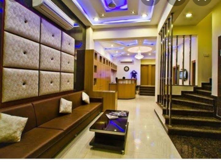 a lobby with a couch and stairs in a building at Hotel Durga Silverline in Jodhpur