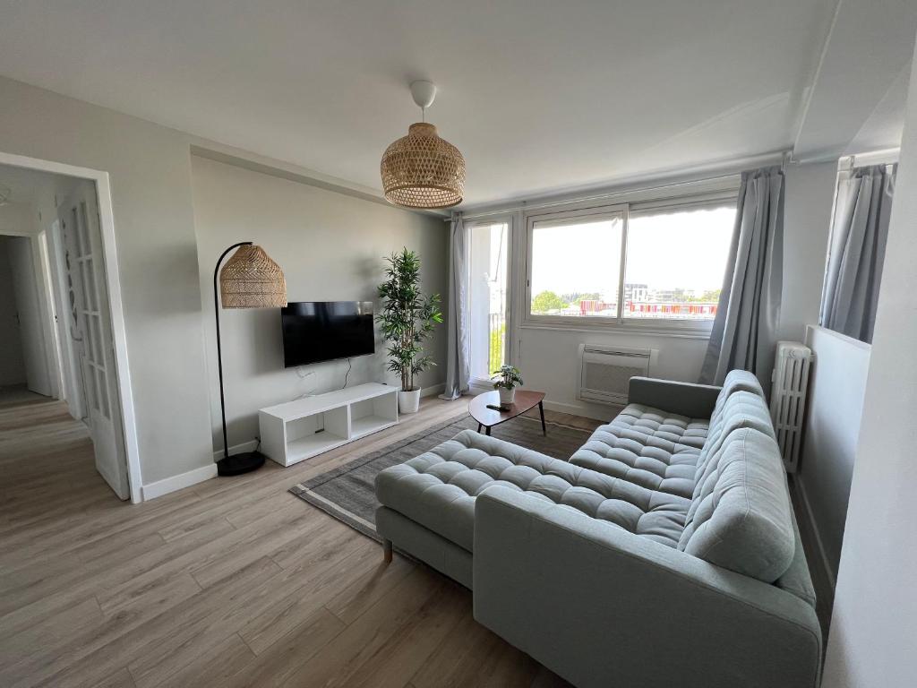 uma sala de estar com um sofá e uma televisão em SUPERBE APPARTEMENT AVEC VUE IMPRENABLE em Castelnau-le-Lez