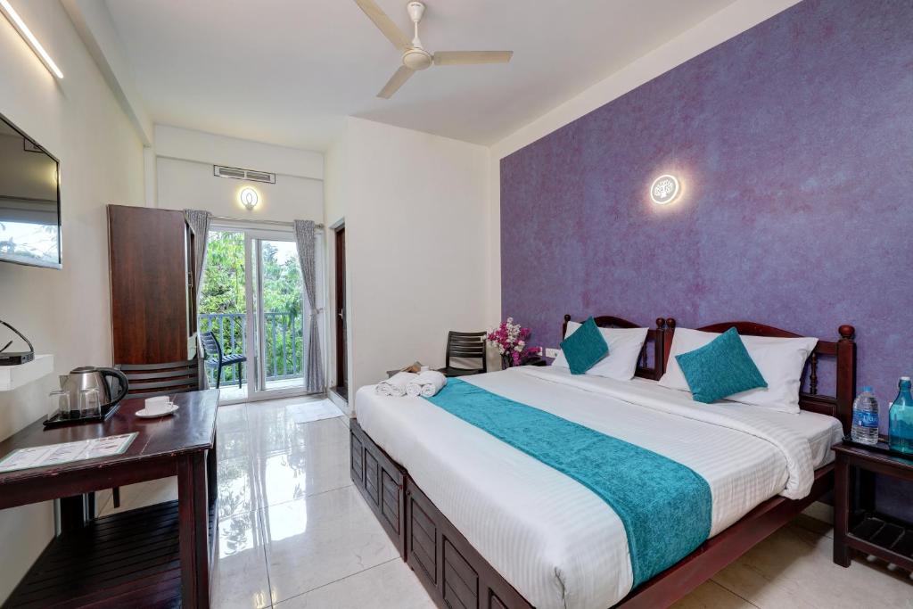 Kurinji Wanderlust Resort Munnar في مونار: غرفة نوم بسرير كبير ومكتب