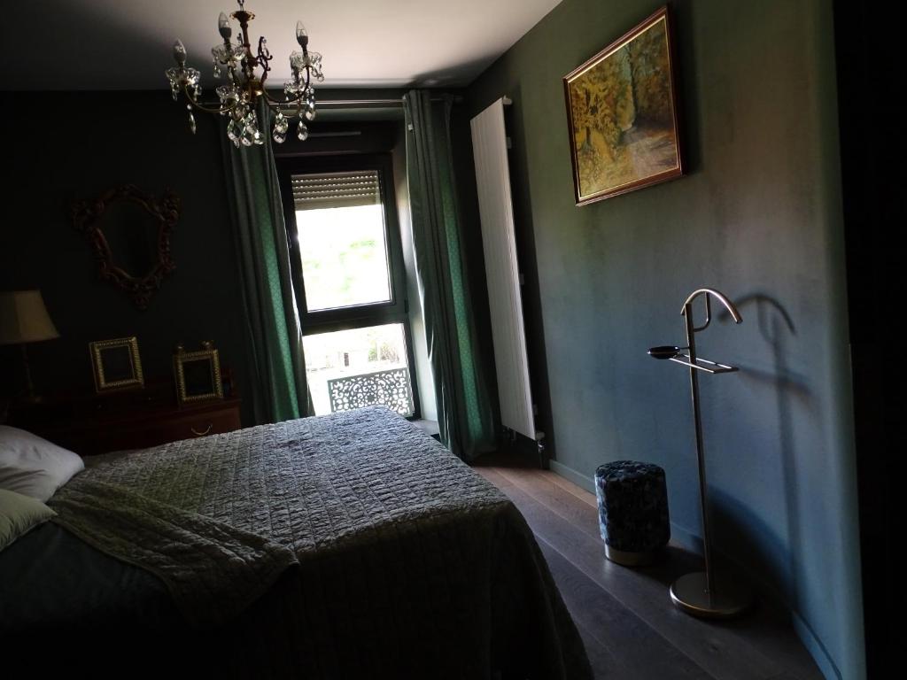 Un dormitorio con una cama y una lámpara. en BOIS DE CHENES HOUSE, en Phalsbourg