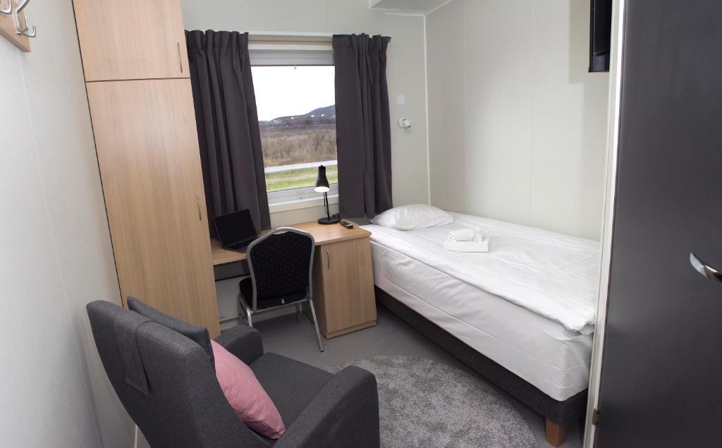 a bedroom with a bed and a desk and a window at Kiruna City Room in Kiruna