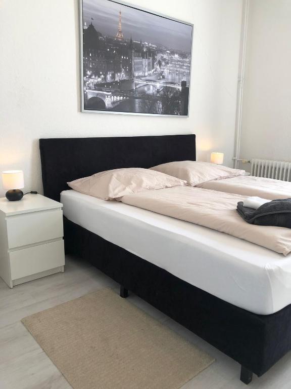 uma cama grande num quarto com uma fotografia na parede em City Apartment Bremerhaven em Bremerhaven
