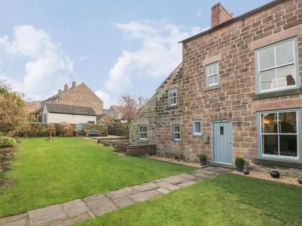 an exterior view of a brick house with a yard at Chevin View in Belper