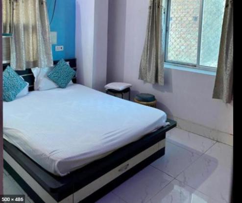 a bedroom with a bed in a room with a window at Zeal Guesthouse By WB Inn in Kānpur