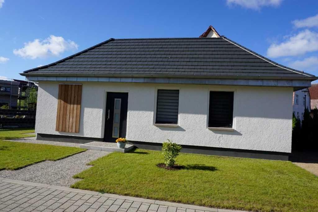 a small white house with a black roof at Ferienhaus "Brigitte" Objekt ID 12053-4 in Waren