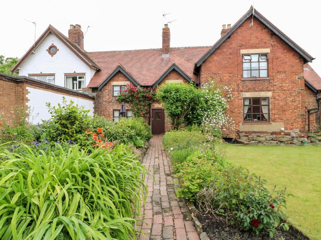 ein Backsteinhaus mit einem Backsteinweg vor einem Hof in der Unterkunft Hobson's Cottage 10 Main Street in Ilkeston