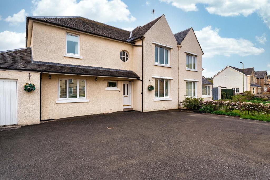 a large house with a parking lot at NEW Four Bedroom House - all rooms ensuite in Stirling