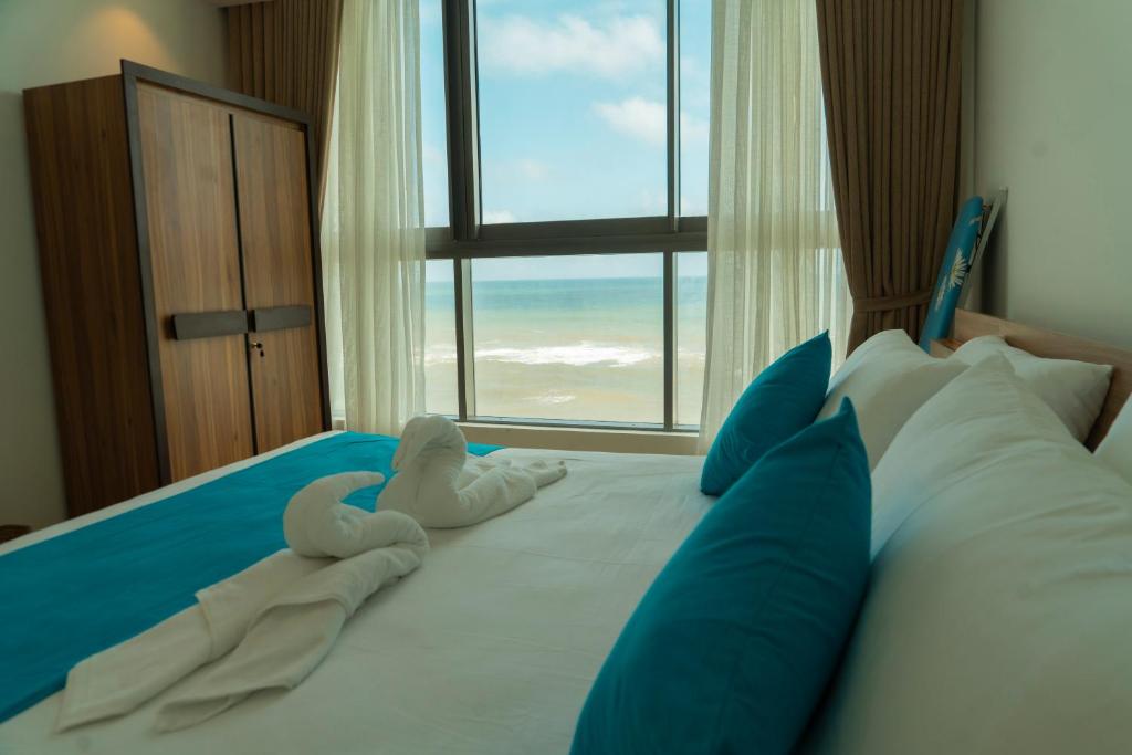 a bedroom with a bed with two swans on it at Oceanfront Galle Apartment L4-10 in Galle
