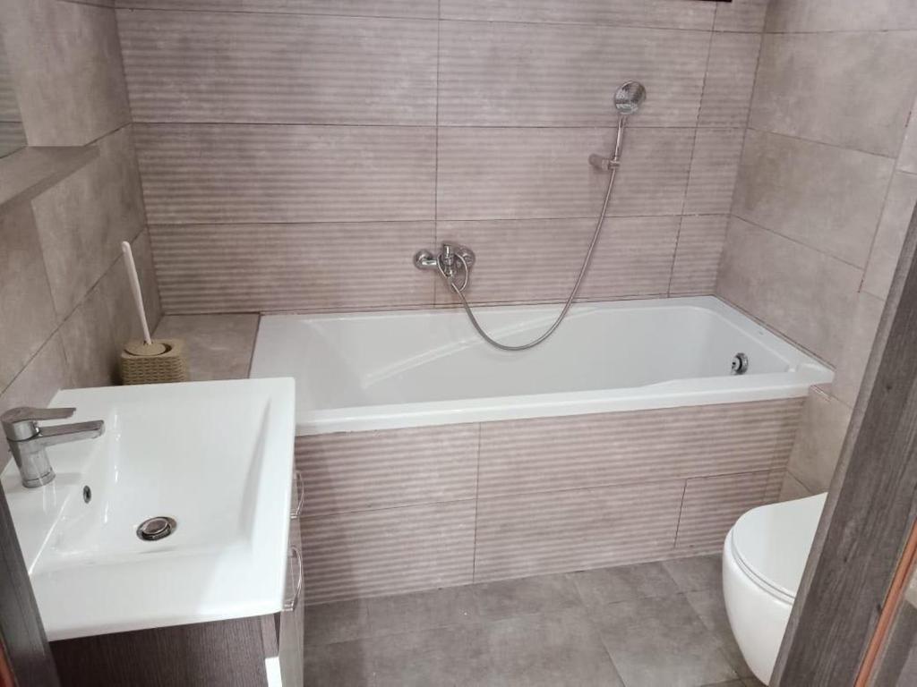 a bathroom with a tub and a sink and a toilet at Superbe Appartement in Sousse