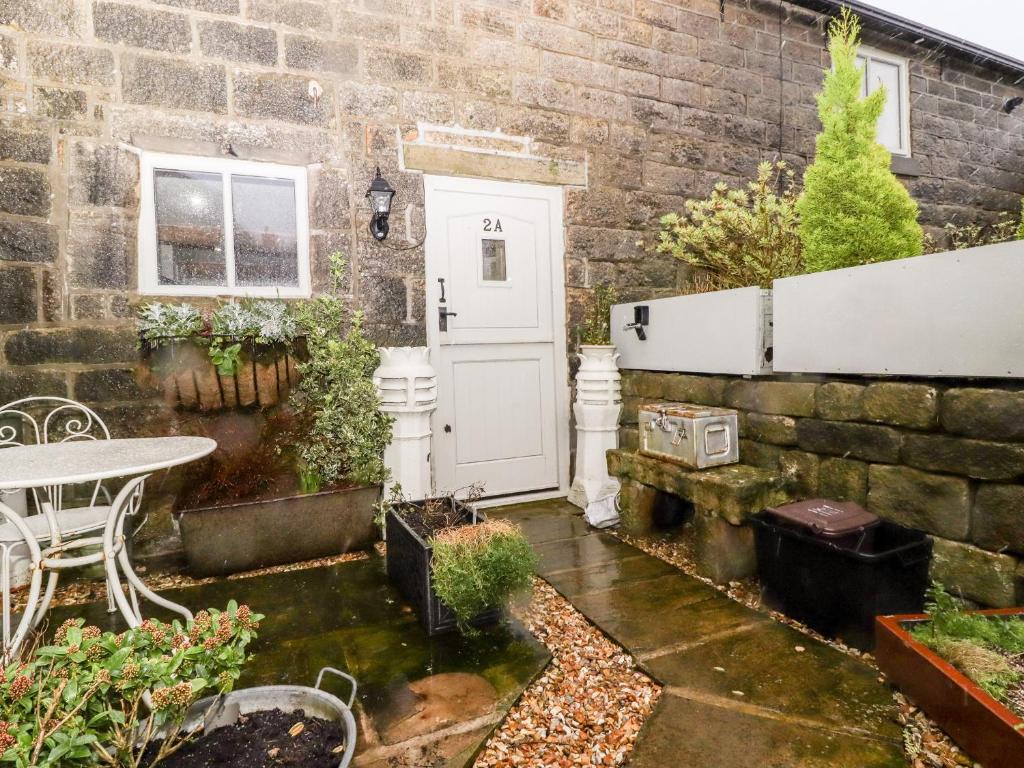 a patio with a white door and a table at 2A Chiserley Stile in Hebden Bridge