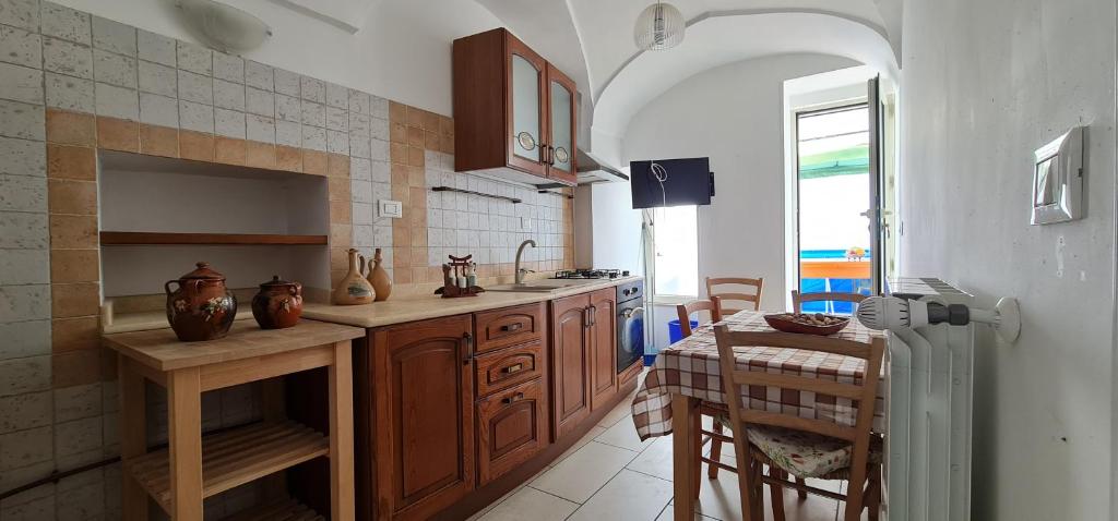 トリカーゼにあるPalazzotto la Volta - Tricaseのキッチン(木製キャビネット、テーブル付)、ダイニングルームが備わります。