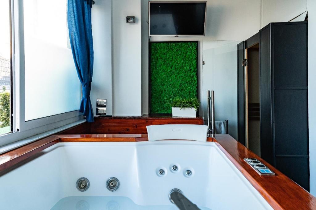 La salle de bains est pourvue d'une grande baignoire blanche et d'une fenêtre. dans l'établissement Covo Degli Angioini, à Naples