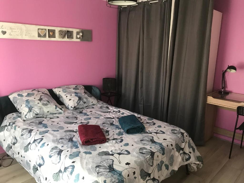 een slaapkamer met een bed met 2 kussens erop bij Agréable Maison au calme in Périgueux