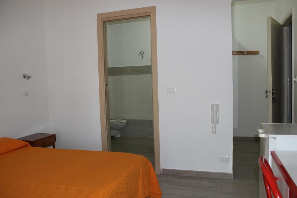 a room with a bed and a bathroom with a toilet at Hotel Conca d'Oro in Stalettì