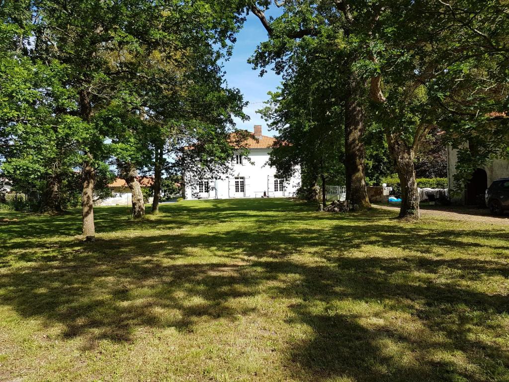 ein weißes Haus mit Bäumen im Hof in der Unterkunft l'Airial de Larroque in Soustons