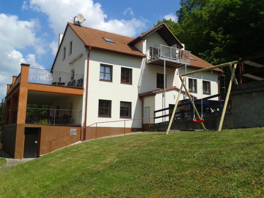 una casa con un parque infantil delante de ella en Ubytovací zařízení en Lovosice
