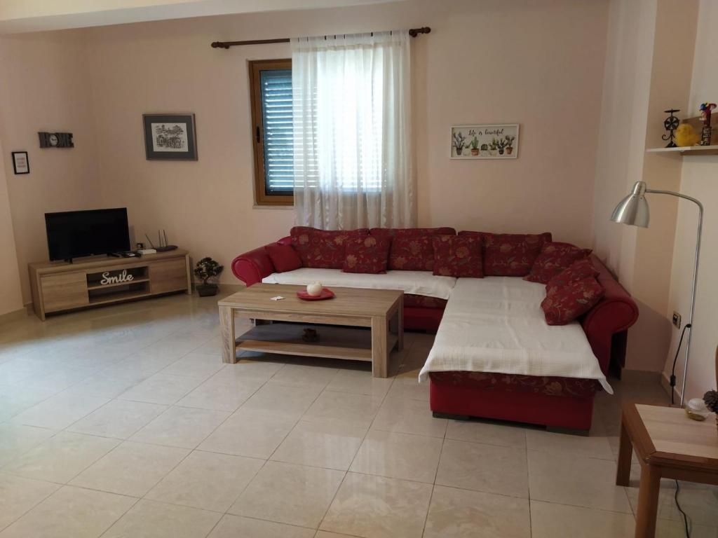 a living room with a red couch and a table at Jozi Kaiser Apartment 2 in Durrës