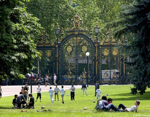 Hotel Belges, a group of people playing soccer in a park at Belges in Lyon