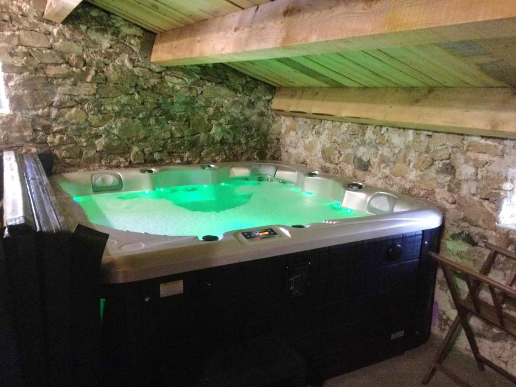 a jacuzzi tub in a stone building at Maison charmante à Lanarce avec vue sur la montagne, jacuzzi. in Lanarce
