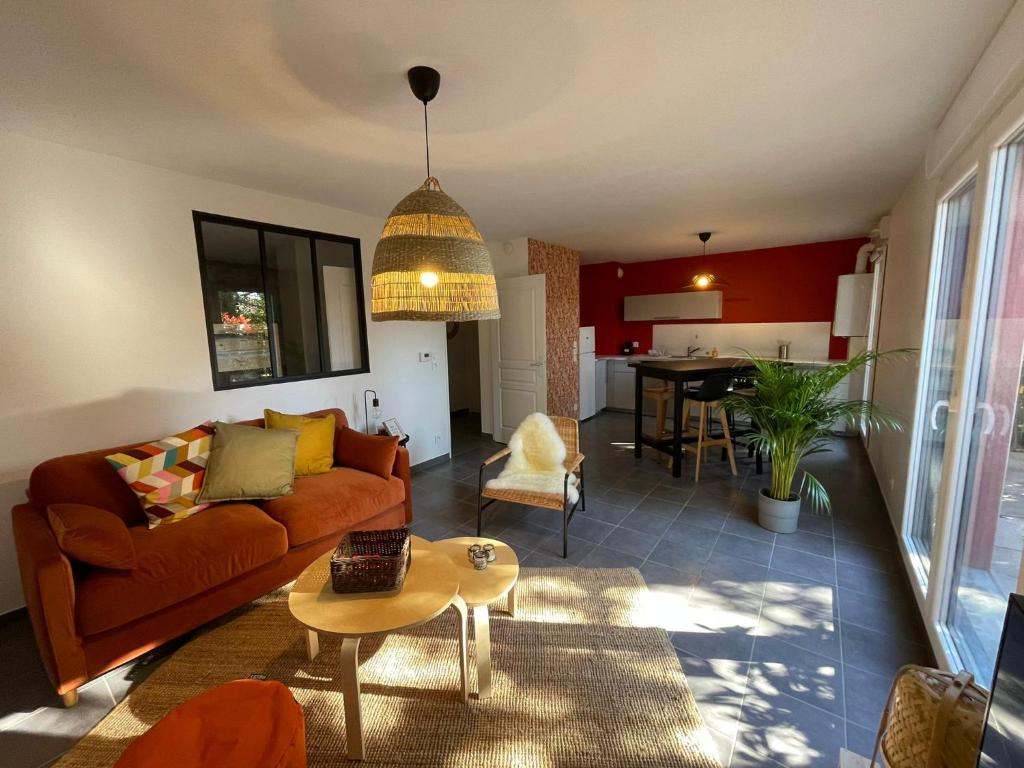 uma sala de estar com um sofá e uma mesa em La Cabane du Loft em Genas