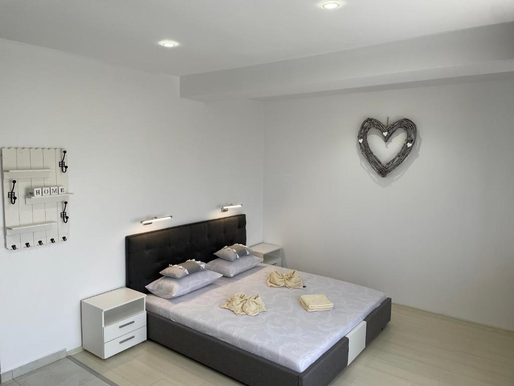 una camera da letto con un letto con un cuore sul muro di Luxory Apartaments 2 a Costinesti