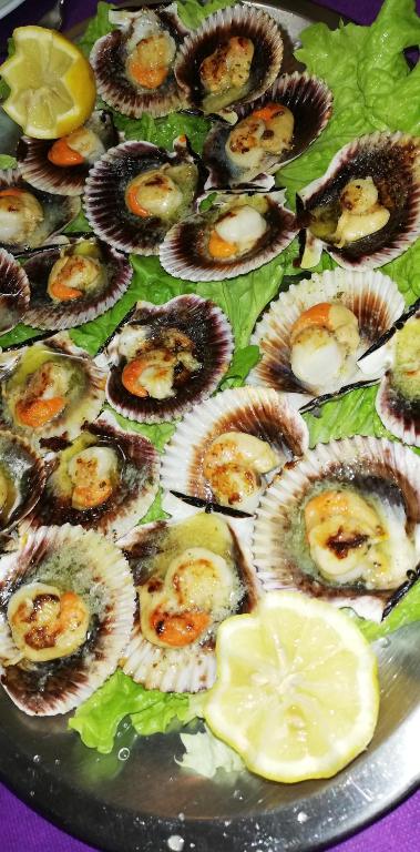a plate of food with oysters and lemon slices at Casa Herbellas in Cedeira