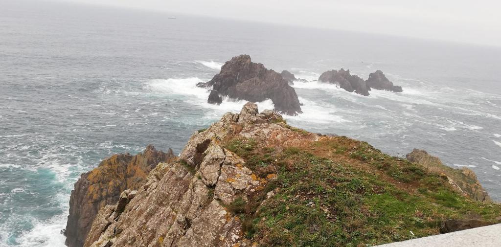 a person standing on top of a rock in the ocean at Casa Herbellas in Cedeira