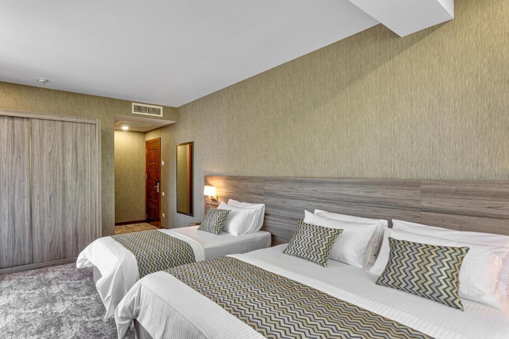 Postel nebo postele na pokoji v ubytování Vinum Hotel
